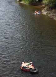 Virgil Beaver reclines on a double tube while floating down the Yampa River on Tuesday under the Ranney Street bridge. Beaver took his daughter and her friend out to enjoy the warm day in cool surroundings.