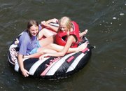 Megan Beaver, left, and Sadye Morgan, both 13, sit across from each other while floating down the Yampa River on Tuesday under the Ranney Street bridge.