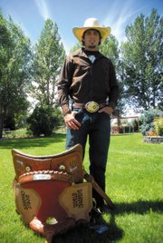 Troy Vernon poses with his championship saddle and belt buckle Thursday in Maybell. Vernon, 19, finished first overall in bull riding at the July 25 to 30 National Little Britches Rodeo in Pueblo.