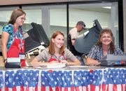 Moffat County election judges Kellie Looper, left, Brandi Meek, middle, and Cindel Nielson, wait to help voters like Robert Clayton, in back, use the electronic system Tuesday at the voting center at Centennial Mall. Area residents also had the opportunity to vote early or with mail-in ballots. Polls are open through 7 p.m. today.