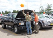 Travis Day, of Meeker, left, looks at the engine of a Ford Ranger with sales associate Jerry Young during a vehicle sale Wednesday in the Kmart parking lot. The Ohio-based G&A Marketing brought about 70 vehicles to Craig for the event.