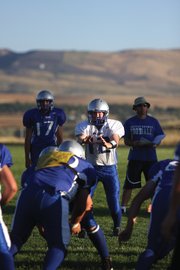 Sophomore Bubba Ivers, center, receives the snap from the shotgun formation during an Aug. 20 scrimmage. The MCHS varsity football team has its first game at 7 p.m. today against visiting Evergreen during a zero week match-up.