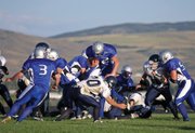 Junior Braeden Sullivan jumps over an Evergreen High School defender during the season opening game Friday at Moffat County High School. The Bulldogs held a lead for most of the game, but lost, 26-22.