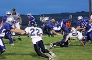 Junior Mason Updike gets upended while running up the middle of the field during the season opening game Friday at the Bulldog Proving Grounds. The Bulldogs lost to the Evergreen High School Cougars 26-22.