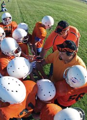 Coaches Mark Balderston, top right, and Billy Bingham, mid right, bring their team, the Bengals, in for a huddle during a break in Craig Parks and Recreation fifth- and sixth-grade Doak Walker Football action Tuesday at Woodbury Sports Complex.