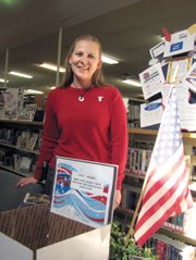 Christy Gonzalez, programs coordinator for the Craig branch of the Moffat County Libraries, poses in front of a donation box Tuesday. Gonzalez is the organizer behind “Project Soldier,” which seeks to collect snacks, books, cards and more to ship to soldiers overseas. The library will collect donations until Dec. 31.
