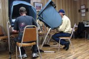 Shawn Bacon, left, and James Cooper sit at electronic voting booths in Hamilton during Tuesday’s election. Cooper, a registered Republican, said he votes independently during most elections. However, this year Cooper is voting a “straight Republican ticket.” Cooper feels this year’s election is a referendum on Democratic policies and “how they were passed.”