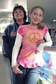 Debbie Winder, 56, poses with her granddaughter, Haleigh Rodela, 11, on Saturday at West Theatre in Craig. Winder has worked at the theater part time for 22 years.