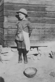 A young Perry Van Dorn prepares for his first day of school in Craig, circa 1920. The building behind him housed six people on land near present-day Tenth Street.