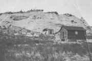 Pictured is the Van Dorn homestead in August 1918. In the foreground is the Van Dorn house. In the background, is the “Indian Cave,” which was dug into the sand rock by the Van Dorns to serve as a chicken coop. The homestead is long gone, but the cave can still be accessed from Tenth Street.