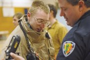 MCHS junior Evan Walters, left, tries on fire gear with the help of Craig Fire/Rescue firefighter Shane Thomas during the school’s Career Day.