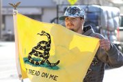 Craig resident Dillon Catt, 19, shows the Gadsden flag to cars passing by Friday at the 2011 Tax Day Freedom Rally hosted by the Bears Ears Tea Party Patriots at the Moffat County Courthouse. The rally was the second of its kind he has attended and he said he was pleased with the turnout.