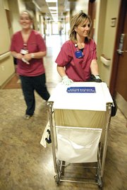 Certified nursing assistants Tiffany Schmedeke, left, and Holly Gurr prepare to discharge a patient Friday at The Memorial Hospital. The hospital board is in discussions with Rural Physicians Group to hire up to four full-time hospitalists.