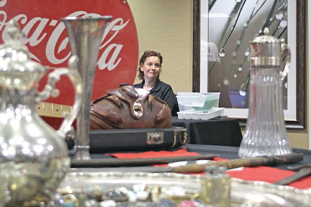 Joan Landquist, a buyer for the International Coin Collectors Association, sits amid numerous displayed antiques during an April show at Craig’s Hampton Inn. ICCA is an associate of Treasure Hunters Roadshow, which will host a show beginning at 9 a.m. today at the Holiday Inn of Craig. While ICCA is more focused on pricing and buying rare coins, THR seeks out antiquities of all sorts, including artwork, jewelry, toys and other items.