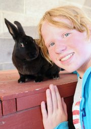 Emma Balstad, 12, poses with her rabbit, Quill, on July 20 at her home in Maybell. Emma will show Quill and other rabbits in August at the Moffat County Fair.