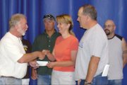 Andy Bullen, chairman of the Yampa Valley Friends of the NRA, presents a $2,000 scholarship check to Deb and Norm Yoast on behalf of their daughter, Lindsay. Lindsay will be starting her second year at Western State College this fall.