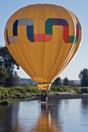A hot air balloon pilot displays skills Saturday by skimming his balloon on top of the Yampa River as part of the Moffat County Hot Air Balloon Festival.