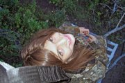 Tiana Nichols, 8, peers upward from a tree stand during the 2010 archery elk season in Moffat County. Tiana accompanies her father on nearly all his hunts.