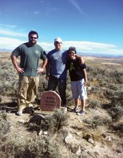 Steamboat Springs residents Jonathan Ritchey, Paxton Ritchey and their mother, Synthia Ritchey, stand near the new headstone for Mary Dillon, who was buried on the site in January 1915. The gravesite is on a hill above Janet Gerber’s home west of Craig. The Ritcheys, who are friends of Gerber’s, offered to help set up the headstone.