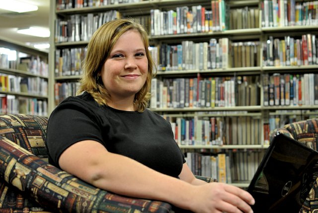 Bethany Longwell, 20, of Craig, poses in the Moffat County Library in Craig with the laptop she uses to write her novel for National Novel Writing Month. This is the first year Longwell is participating in the annual event, which takes place every November and challenges authors to write a 50,000-word novel in a month.