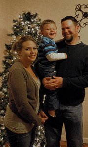 Megan, Kelton and Steve Mudge stand near the Christmas tree inside their home in Craig. Kelton graduated in May from Horizons Specialized Services’ Early Intervention program for developmentally disabled children.