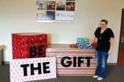 Janna Thompson displays the gift-themed exhibit and message in the lobby of The Journey at First Baptist Church. Thompson said the moral of her Christmas play, “We Three Nails,” which she wrote and directed, has a similar meaning in its display of God’s greatest gift.