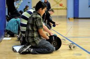 Tanner Hampton, 14, a Craig Middle School eighth-grader, tweaks his mousetrap car Tuesday during the school’s 15th annual mousetrap car rally in the CMS gym. Students used a variety of materials, including CDs and vinyl records, to construct their cars.
