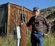 Ray Wagner, 87, stands beside a disconnected electrical box and chopped utility pole in Sept. 2011 at his ranch in Hamilton. Wagner contends Yampa Valley Electric Association unlawfully removed the electrical service from his home, shop and well-house. His son, Jay, filed a lawsuit against YVEA last month in Moffat County District Court.