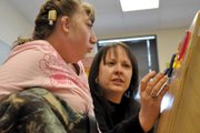 Jennifer Shirley, a Craig Middle School special education teacher, works with Katelynn Hildebrandt, 16, in the special education classroom at the school in mid-February. Because Katelynn cannot speak, her teachers rely on subtle signs, including eye gaze and small movements, to determine what the CMS eighth-grader is thinking and feeling.