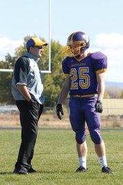 Mike Bates, the Little Snake River Valley (Wyo.) School six-man football head coach, discusses the game plan with senior Daniel Wille during the 2011 playoffs. Wille, who was a sophomore when Bates started the program in 2009, said Bates is a good motivator and easily communicates his expectations to players.