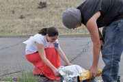 Valerie Jarvis, a Moffat County High School science teacher, helps Gage Gould, an MCHS freshman, put plastic wrap over his solar convection oven Friday at the high school. Jarvis took out about $100,000 in student loans to pay for the last year of her bachelor’s program at Iowa State University and the entirety of her master’s degree from the University of Southern California.