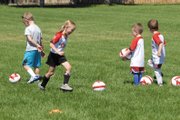 Jolene Rhyne, 5, dribbles her British Soccer Camp ball after doing a ball-control drill. Rhyne and other children ages 3-5 were taught by Kieran Rimmington of Blackpool, England, at the camp, which continues through Friday.