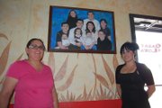 Sandra Loya, left, and Erika Reyes display the Loya family portrait before turning off the lights of Mexican restaurant Casa Loya for the final time. Loya, who has owned the business for the past 11 years, will rent the space to Double Barrel Steakhouse, formerly of Hayden, for the next year as she takes time off to focus on family.