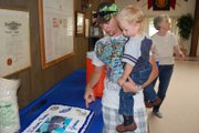 Jordan Bailey and his son, Kaeden, take a look at the cake made for Jordan’s homecoming party after spending several months overseas with the Navy. The picture of the father and son on the cake’s frosting was taken before Jordan shipped out in November 2011.