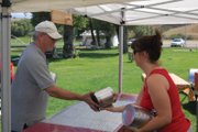 Steve Renfro, left, hands off cooking materials to his wife, Marilyn, as they prepare their station Thursday afternoon for the weekend’s Colorado State BBQ Championship at Craig, hosted in Loudy-Simpson Park. The Renfros, who are from Bailey, head Flyboy BBQ, last year’s grand prize winner.