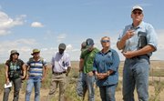 Jim Wurz, foreground, a faculty member at Colorado State University, leads a discussion Wednesday about how the Bureau of Land Management manages multiple use lands in the United States. His group of public land managers from Africa and Latin America were taken to a private ranch near Cross Mountain as part of a tour with Little Snake Field Office employees.