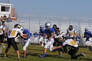 Eli Simpson (center) carries the ball amid traffic Monday during the Moffat County C football team's game vs. Meeker.