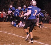 Michael Samuelson (center, carrying the ball), falls backward for a couple extra yards on a carry in the first half Friday night. Samuelson had two rushing touchdowns in the game.