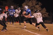 Bubba Ivers carries the ball and splits two Battle Mountain defenders during the first half of Friday's game at the Bulldog Proving Grounds. Moffat County won, 48-14.