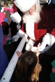"Santa Claus" hands out candy canes to Craig elementary students and residents Tuesday at the Moffat County Fair Grounds during the Capitol Christmas Tree stop. Harvested near Meeker, the tree is touring Colorado on its way to Washington, D.C.