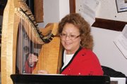 Charleah Firestone plays the harp Thursday night at the Festival of Trees at the Moffat County Courthouse.