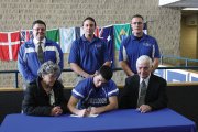 Jacob Teeter, a senior at Moffat County High School, signs his letter of intent to play football at the United States Merchant Marine Academy next year. Teeter was planning on attending a service academy, and was invited to join the USMMA football team recently. He was joined by his grandparents, Mary and Gene Teeter (front), as well as (back row, from left) Moffat County School District Athletic Director Jeff Simon, head football coach Kip Hafey and assistant coach Lance Scranton.