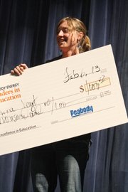 Brynna Vogt, a seventh grade science teacher at Craig Middle School, accepts a check Wednesday as part of the Peabody Leaders in Education award, which she was presented with during a surprise assembly.