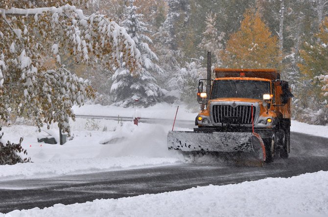 A city snowplow clears heavy snow off of Aspen Wood Lane early Friday morning.