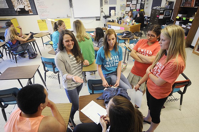 Hayden High School teacher Kendra DeMicco, left, speaks with students Friday who are raising money to help Syrian refugee children in Turkey.